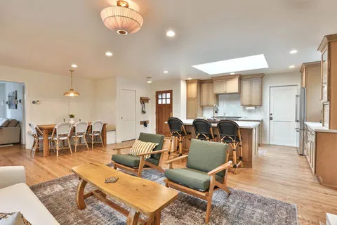 Open-concept living room and kitchen with stylish furniture, hardwood floors, and modern lighting, designed by D.R. Domenichini Construction in Morgan Hill.