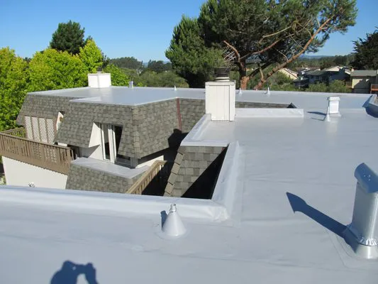 Flat rooftop with clean installation, surrounded by trees and residential buildings, showcasing Daddario Roofing Company, Inc.’s craftsmanship in Capitola.