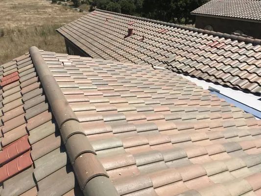"A close-up view of a well-constructed tile roof under clear skies, showcasing the craftsmanship of Daddario Roofing Company, Inc. in Capitola."