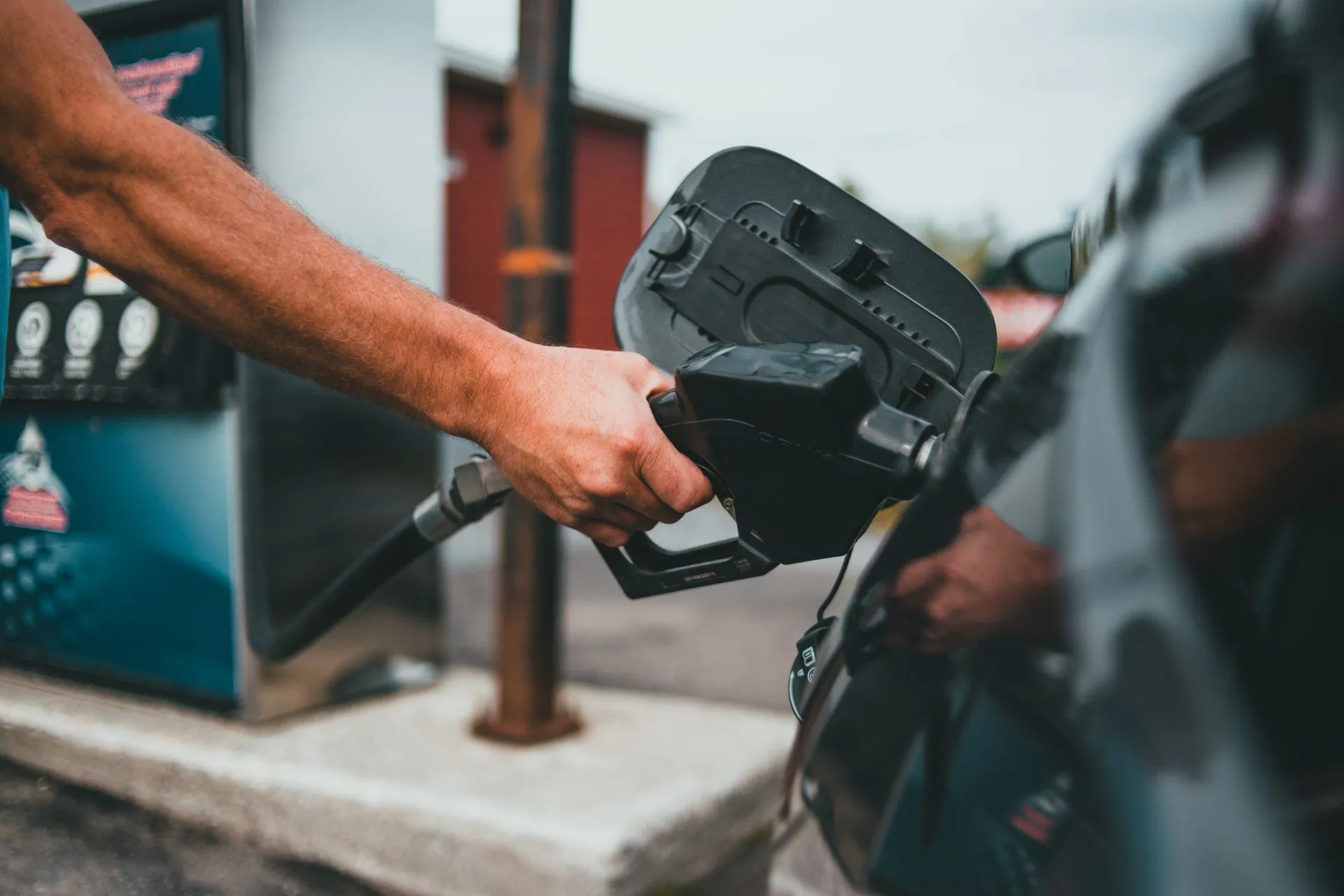 "A hand refueling a car with a gasoline pump at a station, emphasizing the attention to detail offered by DanaMeyerAutoCare in Albany."