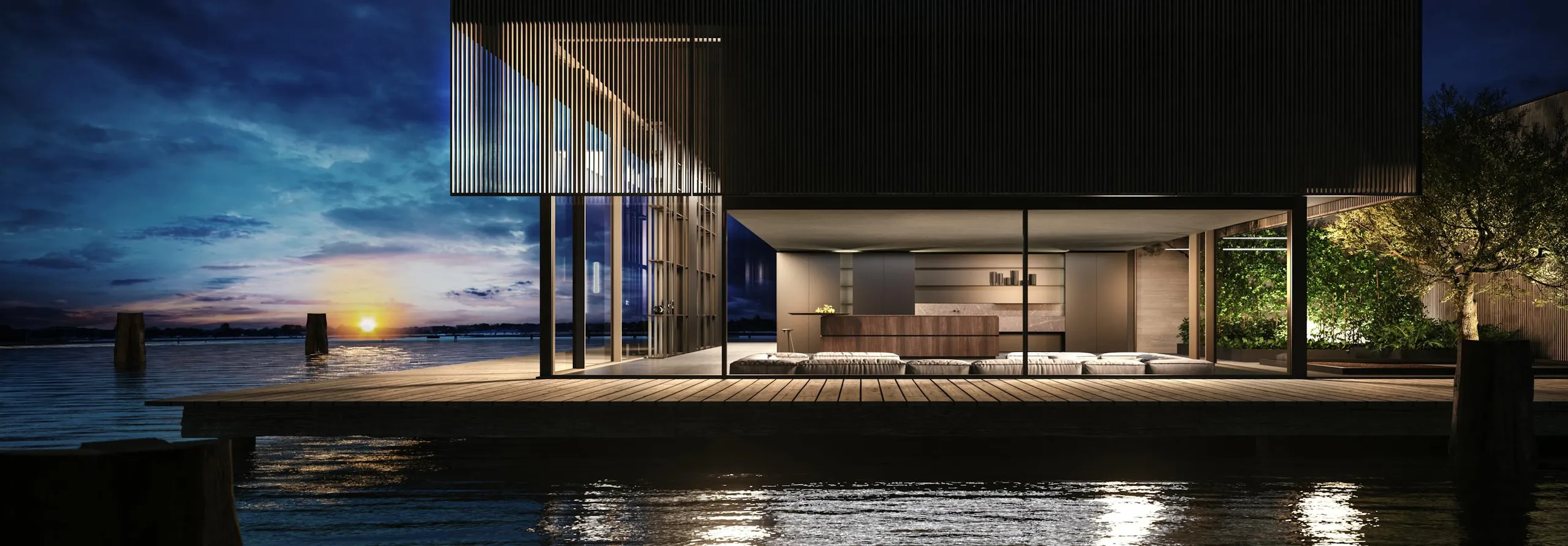 A modern lakeside house at sunset featuring an elegant design with spacious wooden decking and large glass walls, showcasing the work of Danville Hardwood Company.