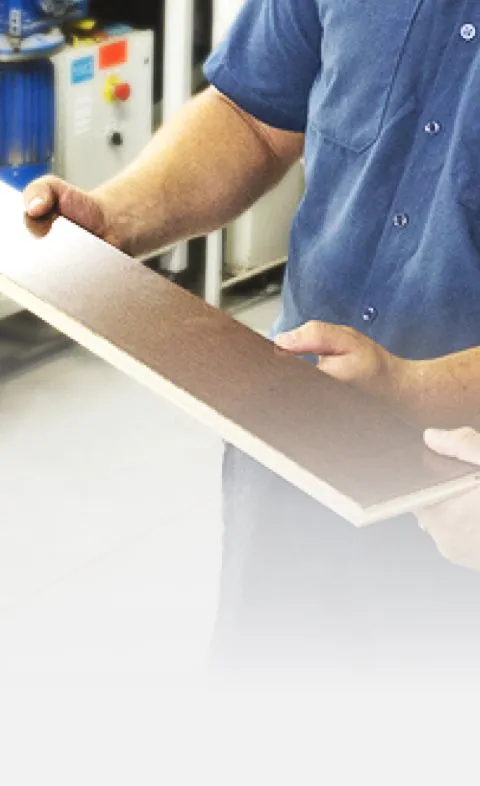 A person holding a wooden plank, showcasing the quality craftsmanship of Danville Hardwood Company in Danville.