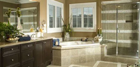 Elegantly remodeled bathroom featuring a large bathtub, glass shower, double sink vanity, and decorative plants, showcasing David Bianchi Home Repair, Inc.'s work in Vacaville.