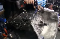 A mechanic working on a vehicle transmission at Delta Transmission in Antioch, showcasing the intricate details and parts.