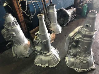 Multiple car transmissions lined up on a workshop floor at Delta Transmission in Antioch.