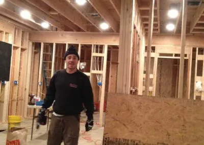 A construction worker standing inside a partially constructed wooden building framework with exposed beams, representing the work of DiazandSonsConstruction in Santa Rosa.