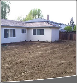 A freshly leveled backyard of a house with bare soil, prepared for landscaping by Dig & Demo in San Ramon.