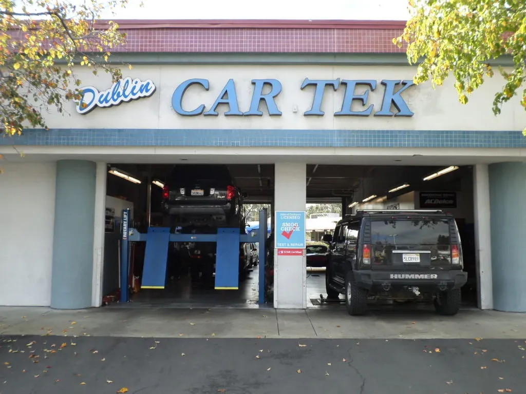 Exterior view of Dublin Car Tek auto repair shop in Dublin, featuring vehicles being serviced in open garage bays.
