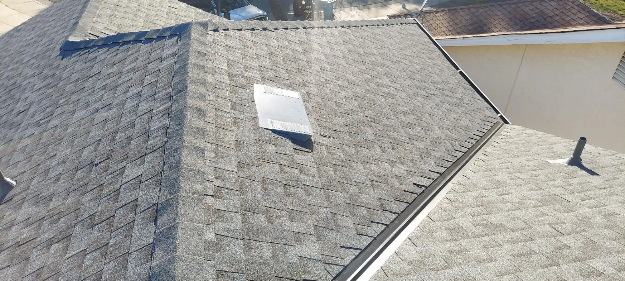 Aerial view of a well-maintained shingle roof with a vent, showcasing the craftsmanship of Dynamic Roofing Inc. in Antioch.