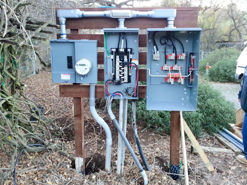 Three open electrical panels mounted on a wooden structure, displaying various circuit breakers and wiring, installed by E.G. Electrical Services in Campbell.
