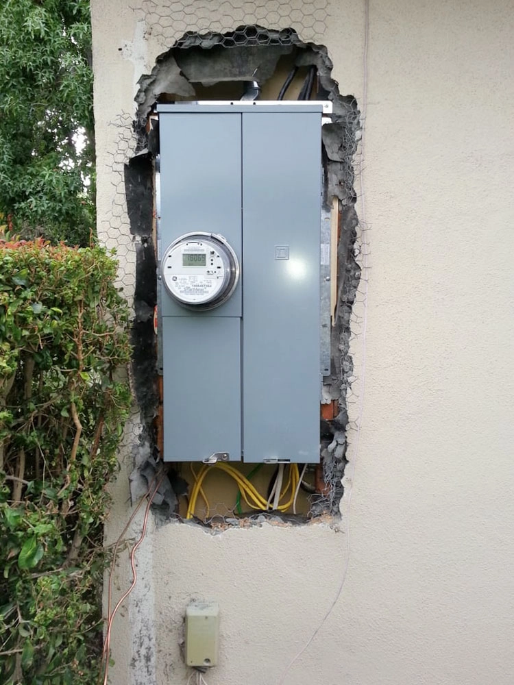 "An electrical panel installed in a wall with visible exposed wires, showcasing the work of E.G. Electrical Services in Campbell."