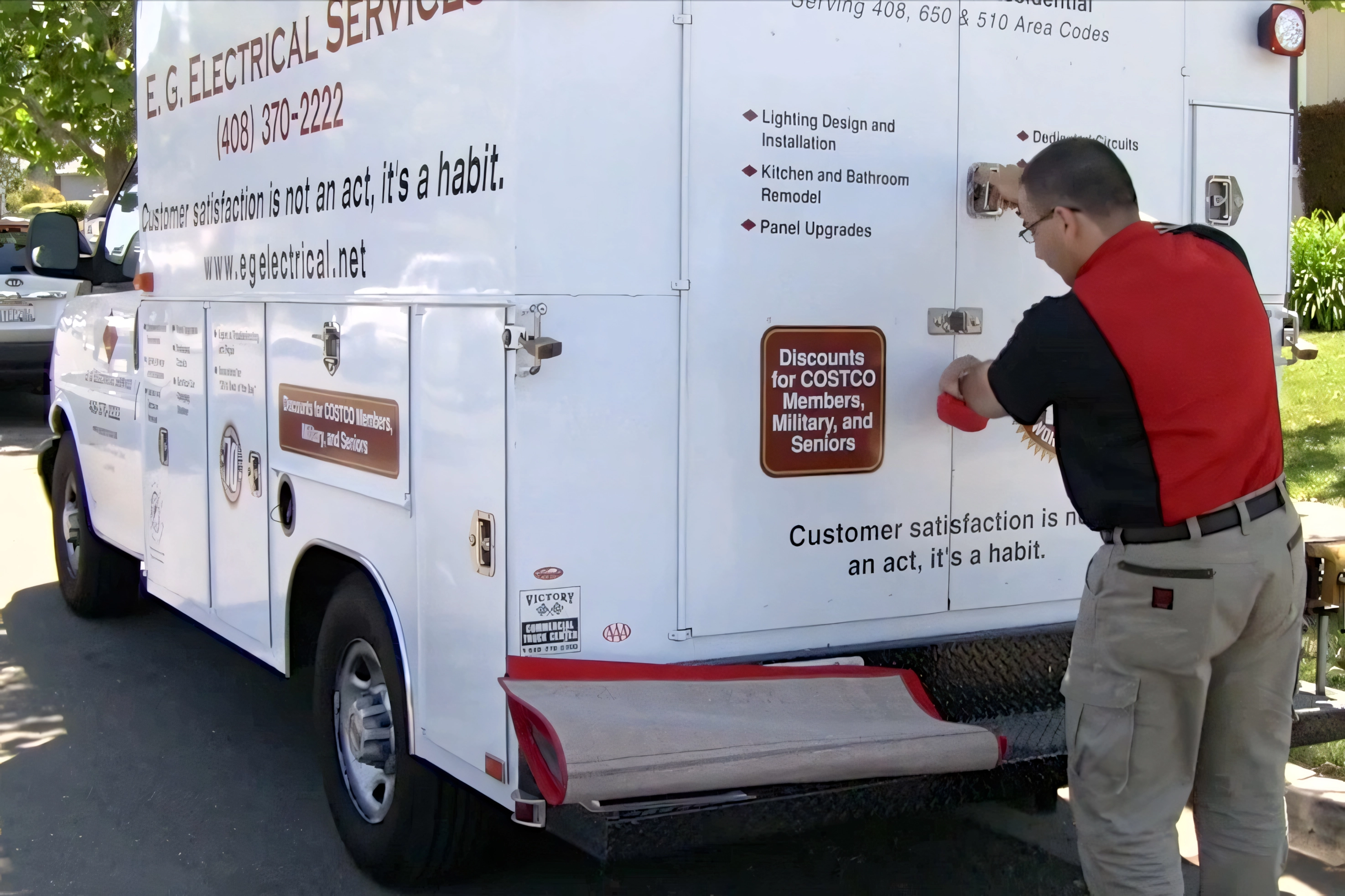 "E.G. Electrical Services employee in Campbell opens the back of an electrical service truck with signage emphasizing customer satisfaction."