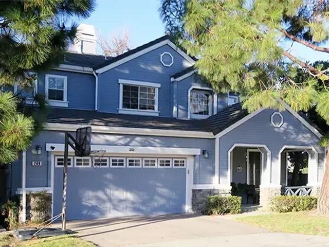 A two-story house in Mountain View, painted in shades of blue and white with a well-maintained front yard, featuring the work of El Gato Painting & Restoration, Inc.