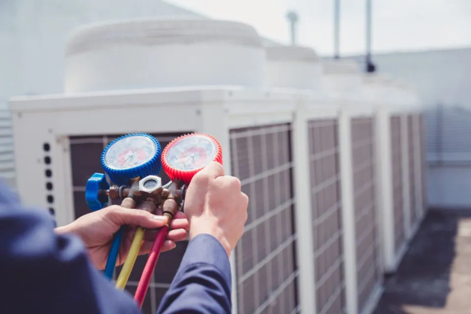 Technician using gauges to calibrate HVAC units at Enviro Heating & Air Conditioning, Inc. in Rohnert Park.