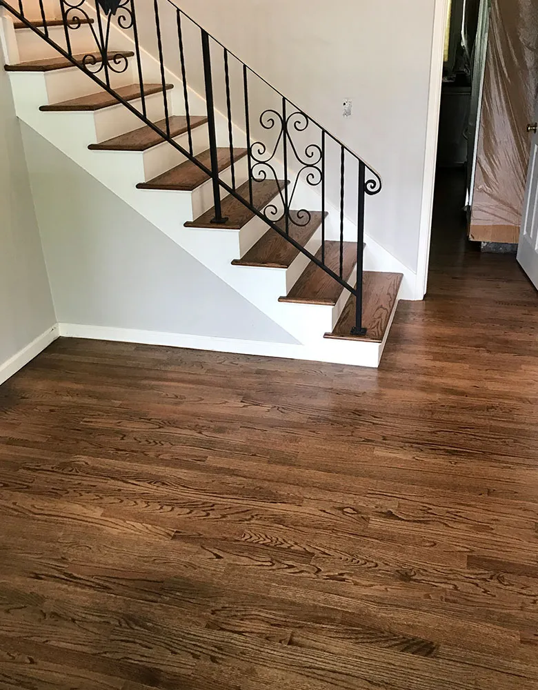 A wooden staircase and floor installed by EuropeanHardwoodFloors in PleasantHill, showcasing quality craftsmanship and elegant design.
