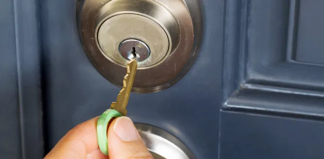 A hand inserting a key into a door lock, illustrating secure access provided by First Lock & Security Technologies in Los Altos.