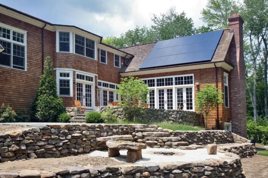 A house with solar panels on the roof, surrounded by a stone-paved patio and garden, installed by Freedom Solar, Inc. in Campbell.