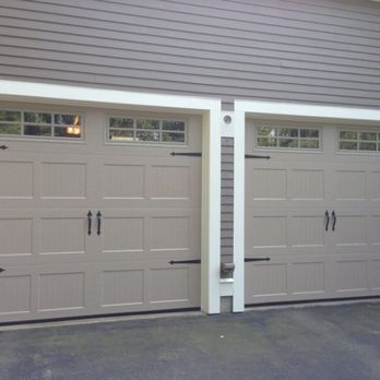 "Two beige garage doors with black handles and windows at the top, installed by Garage Door Experts Repair & Installation, LLC in Fremont."