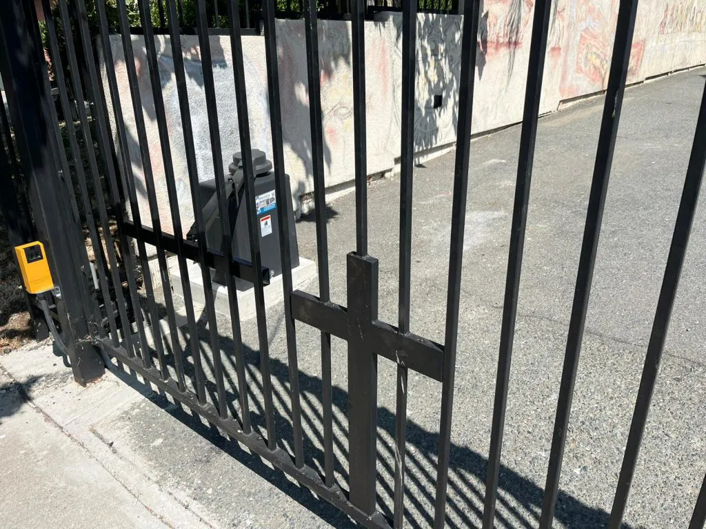 A sturdy metal gate with an automated control system, as seen in a residential area, showcasing the services provided by Garage Door Pros in Sunnyvale.