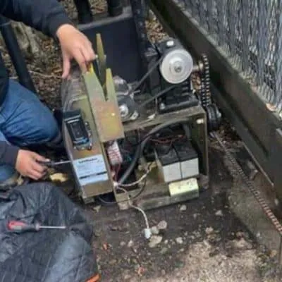 "Technician repairing garage door mechanism outdoors, highlighting the expertise of Garage Door Pros in Sunnyvale."
