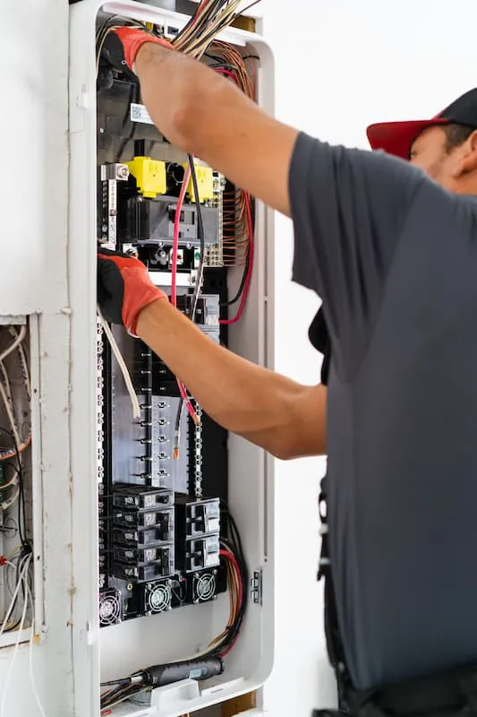 Technician working on an electrical panel, wearing gloves, at Got Watts Electric, Solar & HVAC in Concord.