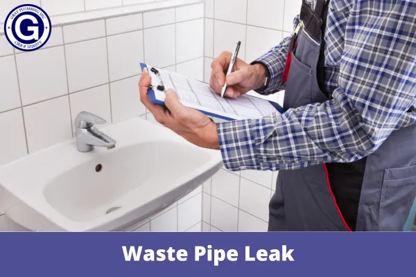 "A plumber from Gray Plumbing Inc in Fairfield examines a bathroom sink for possible waste pipe leaks, holding a clipboard for evaluation."