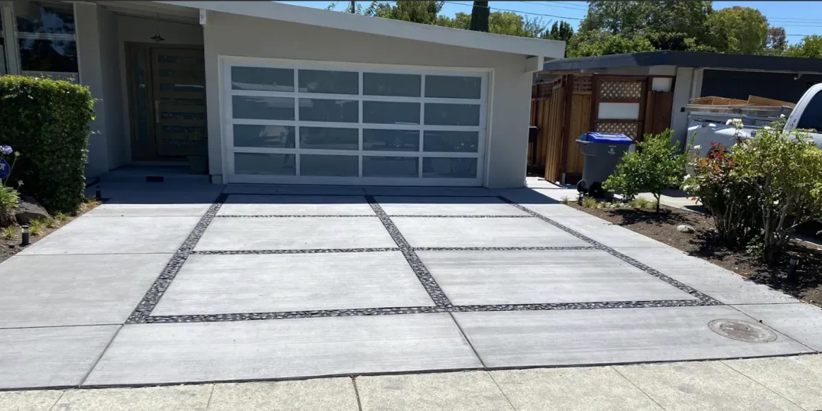 A modern driveway in Los Altos created by Grimes Natural Landscape, featuring a sleek design with concrete slabs and gravel accents.