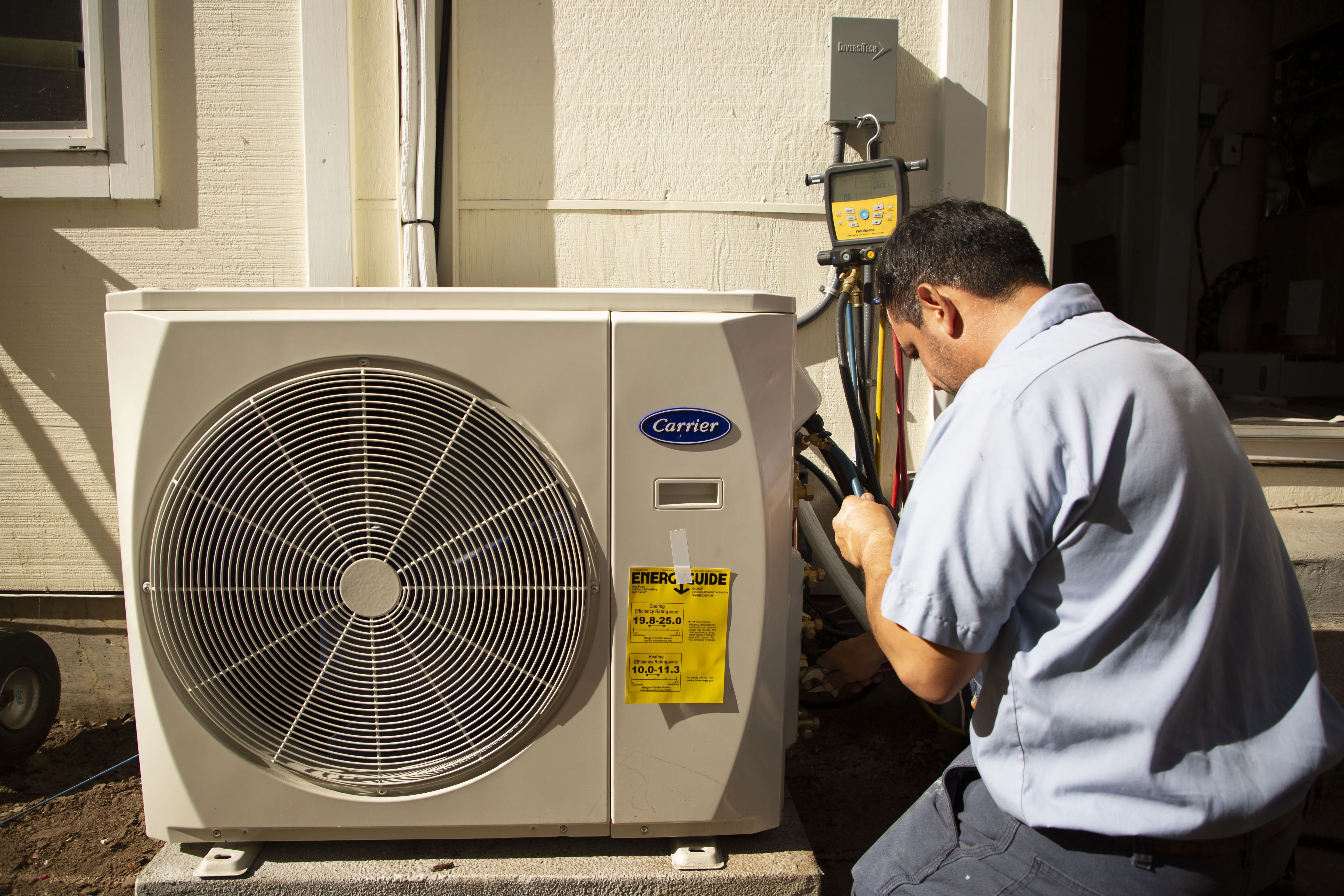 Technician repairing an outdoor HVAC unit with precision, part of the services provided by Hassler Heating & Air Conditioning, LLC in El Cerrito.