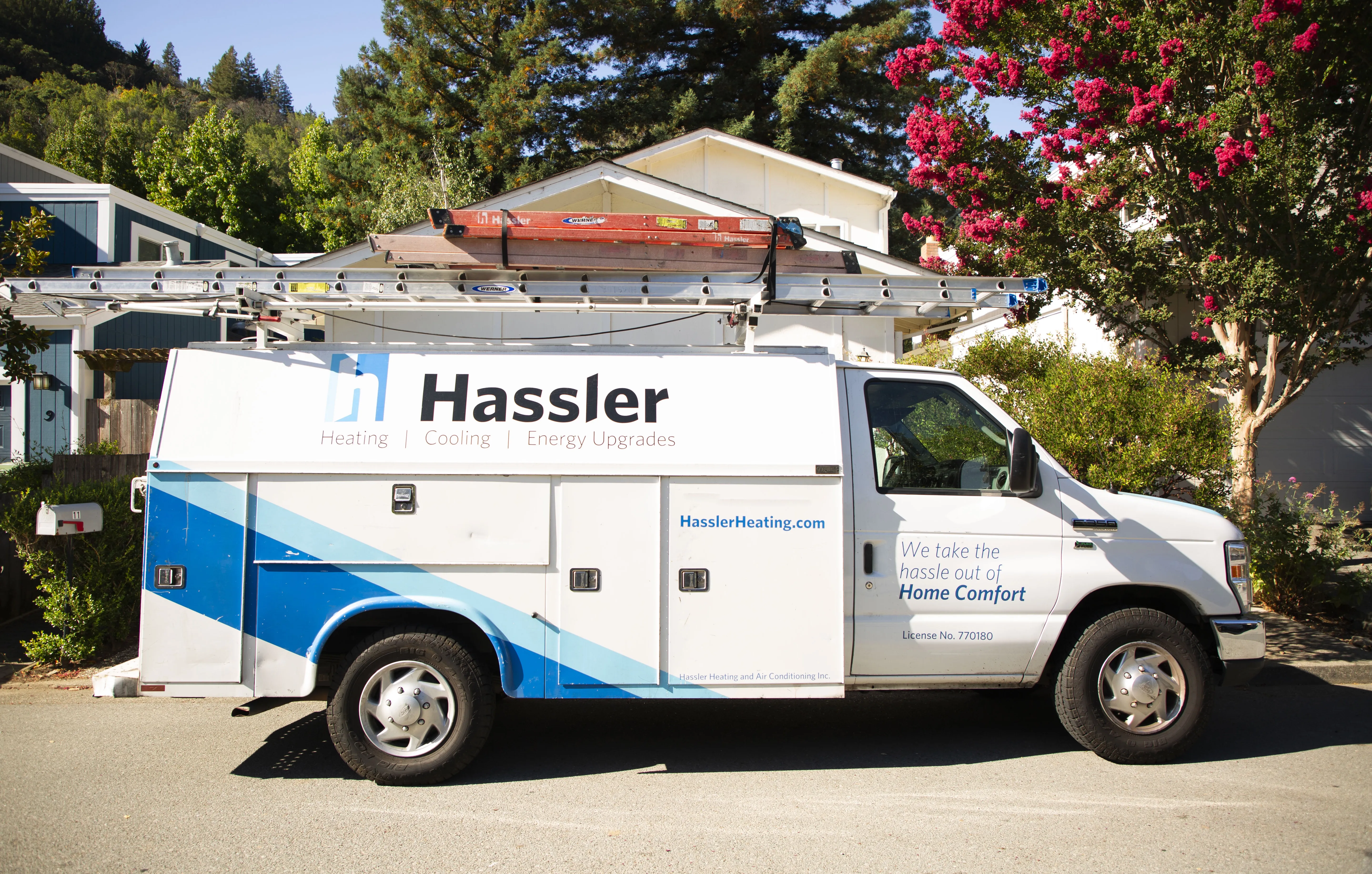 White service van for Hassler Heating & Air Conditioning, LLC parked under trees in El Cerrito.