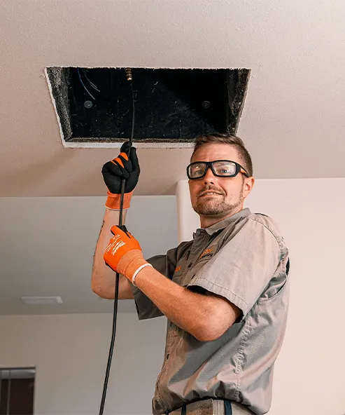 "Technician cleaning an air duct, representing Heating And Air Experts in Fremont."