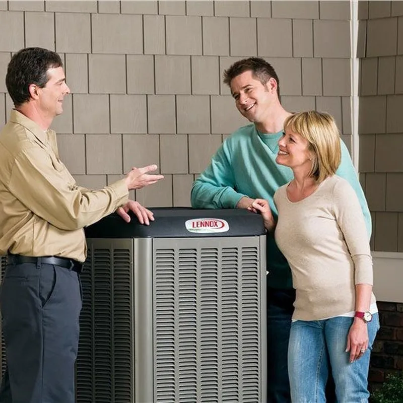 A professional from Heating And Air Experts discusses an air conditioning unit with two homeowners in Fremont.