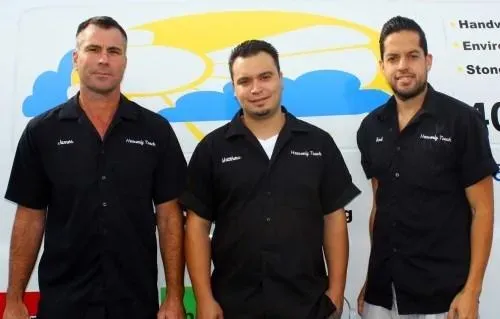 Three men in black shirts with "Heavenly Touch" logos standing in front of a van displaying a cloud logo.