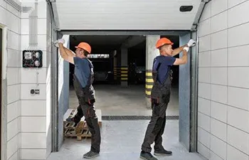 Two technicians in orange helmets installing a garage door, representing Help Garage Door in Sacramento.