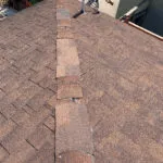 A close-up view of a rooftop with a ridge of shingles, highlighting the detailed work done by ImRoofingCompany in Pacifica.
