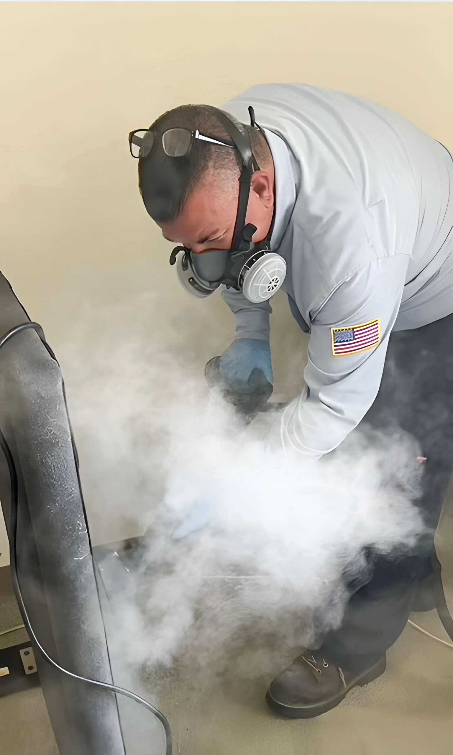 A pest control worker using a fumigation device, surrounded by smoke, wearing safety gear with an American flag patch, representing Integrated Pest Control Management Inc. in Ontario.
