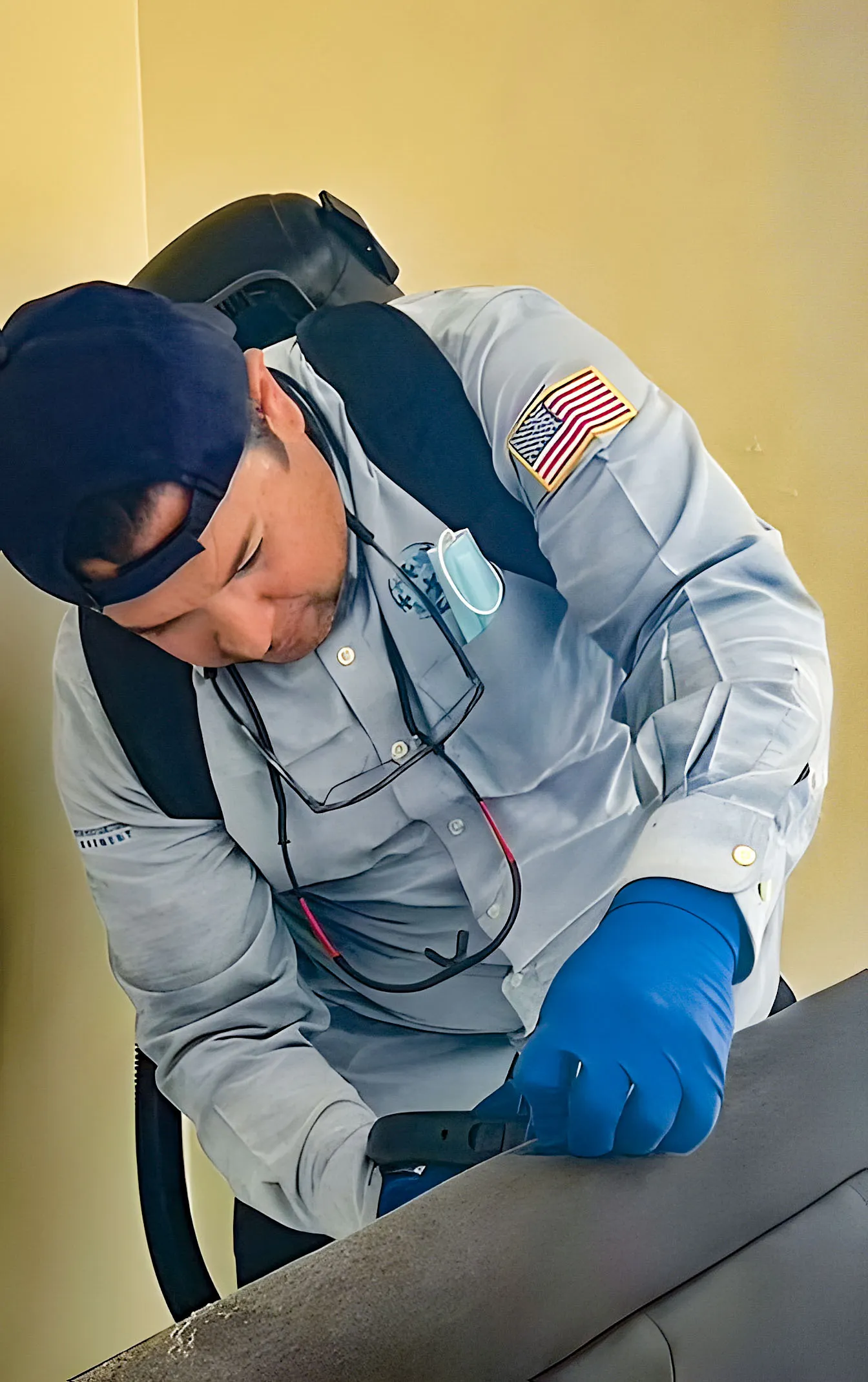 A pest control technician from Integrated Pest Control Management Inc. diligently working on a project in Ontario, wearing protective gear and focused on his task.