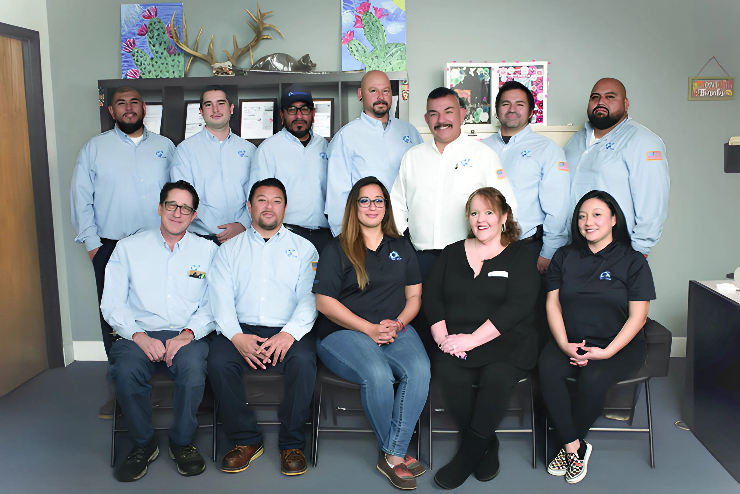 A group photo of the team from Integrated Pest Control Management Inc. in Ontario, featuring twelve employees in uniform, standing and sitting in an office setting.