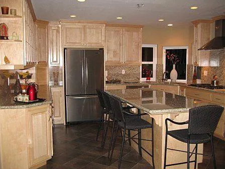A modern kitchen with wooden cabinets, a large island, and stainless steel appliances, designed by Irwin Construction Kitchen and Bath in Gilroy.