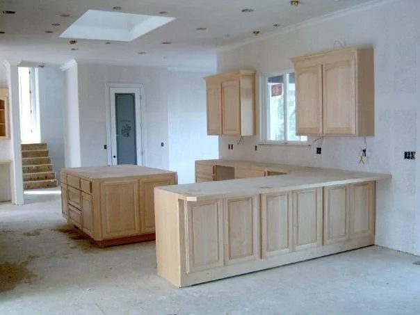 A spacious and unfinished kitchen with light wood cabinetry and two central islands, showcasing the construction work by Irwin Construction Kitchen and Bath in Gilroy.