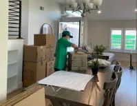 A mover from JC Express Movers organizing boxes in a home in Walnut Creek.