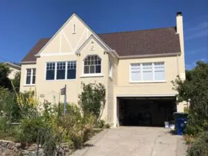 A freshly painted two-story house with cream-colored walls, showcasing the work of J & J's Final Coat Painting, Inc. in Concord.