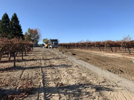 A construction site in a vineyard, featuring a truck and machinery from Jackson's Paving & Equipment Rentals, Inc. on a clear day in Santa Rosa.