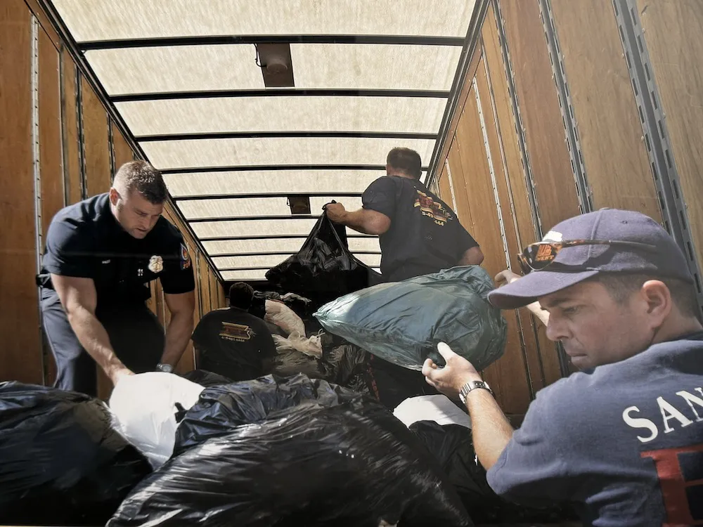 Several individuals in uniform diligently arranging bags inside a moving truck, showcasing the efficiency and teamwork of Johnson & Daly Moving & Storage based in San Rafael.