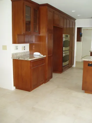 A modern kitchen with wooden cabinetry and stainless steel appliances, remodeled by Kaljian Construction Inc. in Concord.