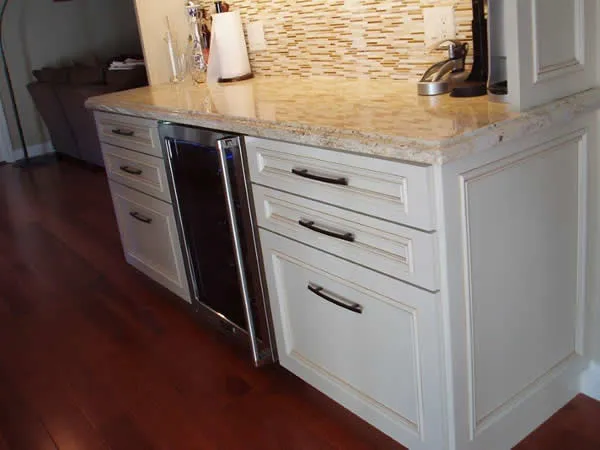 A kitchen view featuring white cabinetry and a small built-in refrigerator, showcasing Kaljian Construction Inc.'s work in Concord.