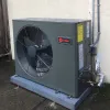 Outdoor HVAC unit installed on a concrete slab beside a building.