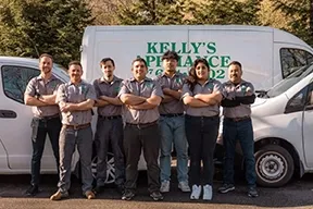 A group of employees from Kelly's Appliance Center in Cotati, standing in front of their service vans.