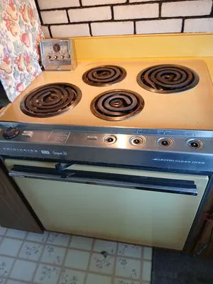 A vintage electric range and oven with coiled burners, displayed in a kitchen setting.