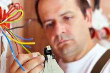 A handyman using pliers to work on electrical wiring.