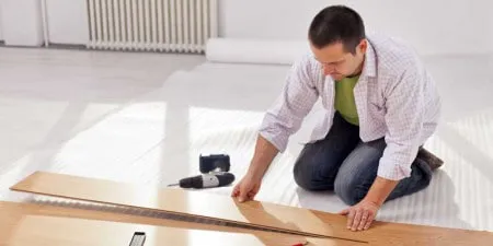 A worker measuring wooden flooring with tools at hand, representing LW Construction & Handyman Services in American Canyon.
